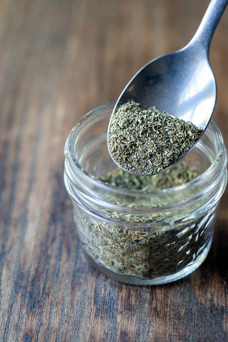 Homemade Italian Seasoning in a mason jar with a spoon