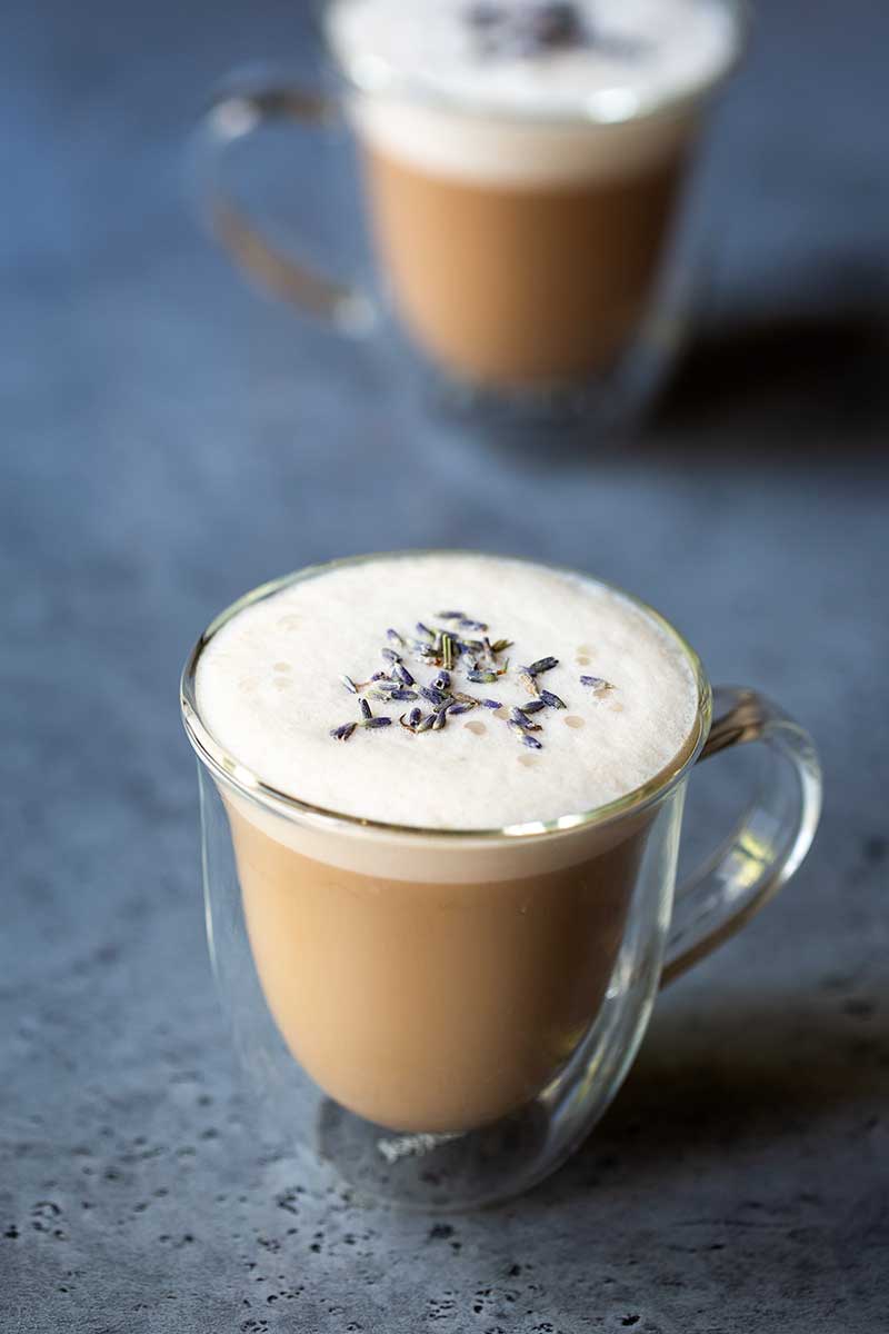 London Fog latte drink in a clear mug, topped with dried lavender