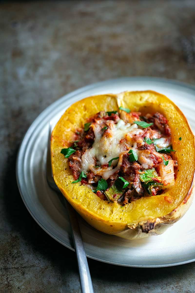 A Baked Spaghetti Squash Boat on a plate next to a fork