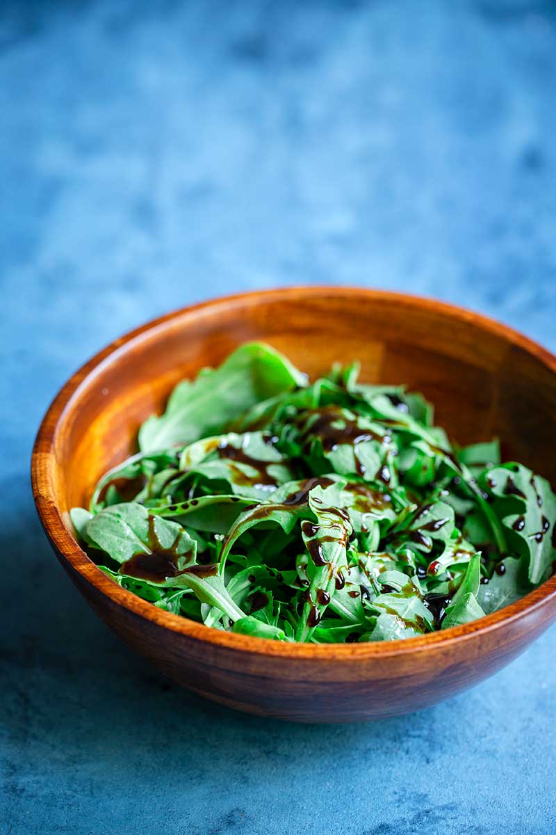 Balsamic reduction recipe drizzled over arugula