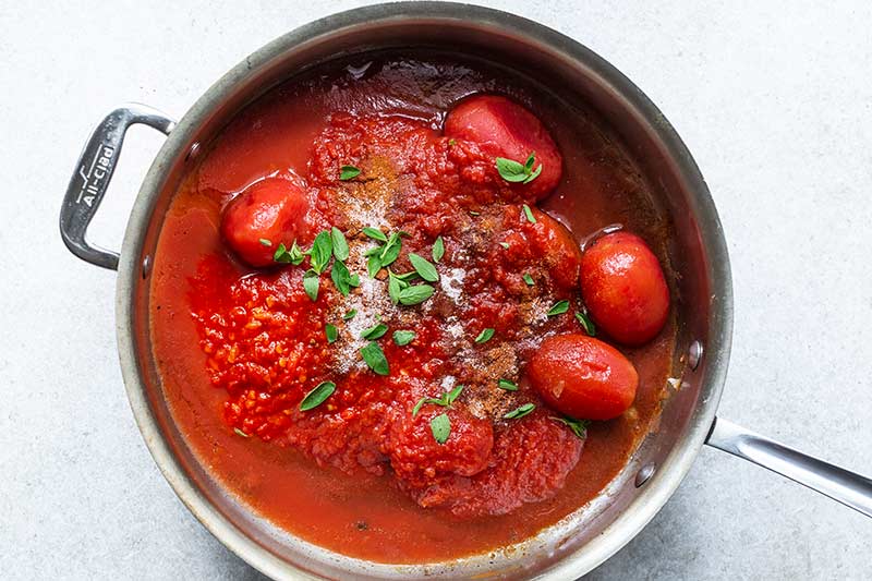Unmixed ingredients for tomato sauce in skillet