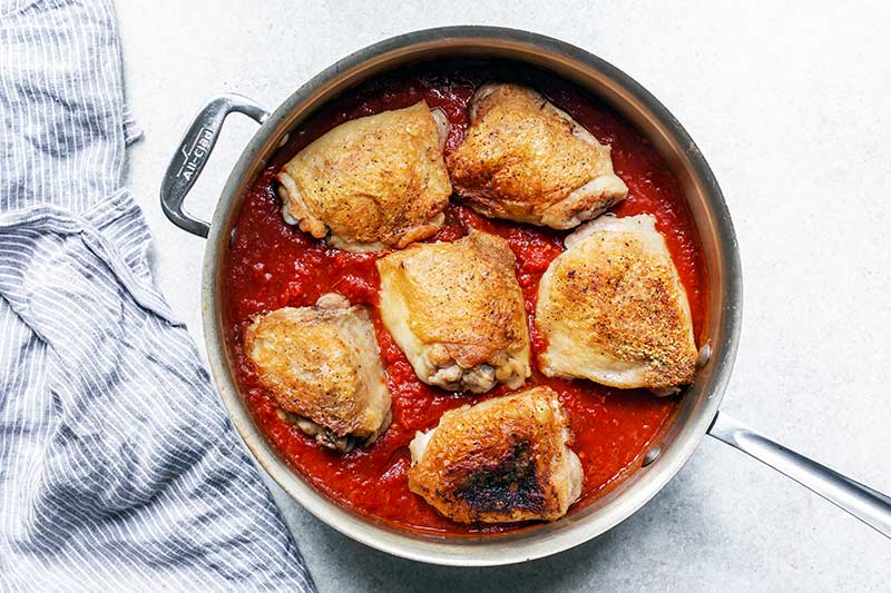 chicken placed back into the skillet, nested in the sauce