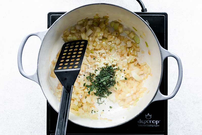 Garlic and sage being added to the chopped onions