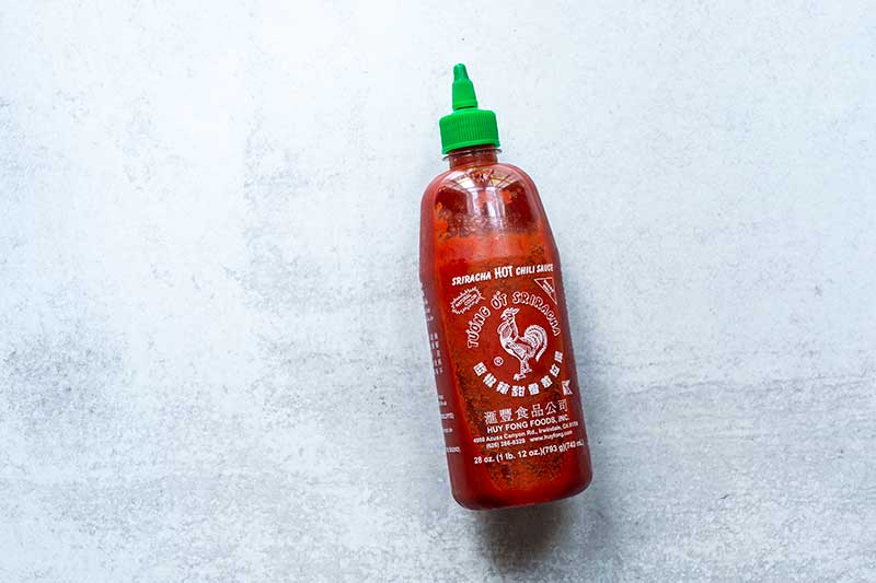 bottle of Huy Fong sauce for "does sriracha go bad" article