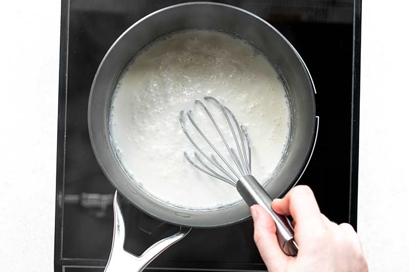 whisking cream and milk to make sauce for broccoli with cheese sauce