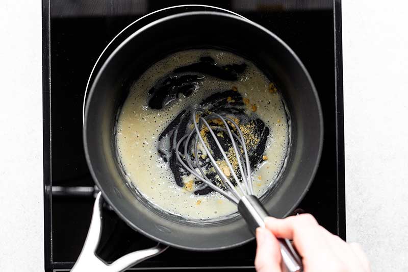 Adding seasonings to roux including dry mustard and cayenne pepper