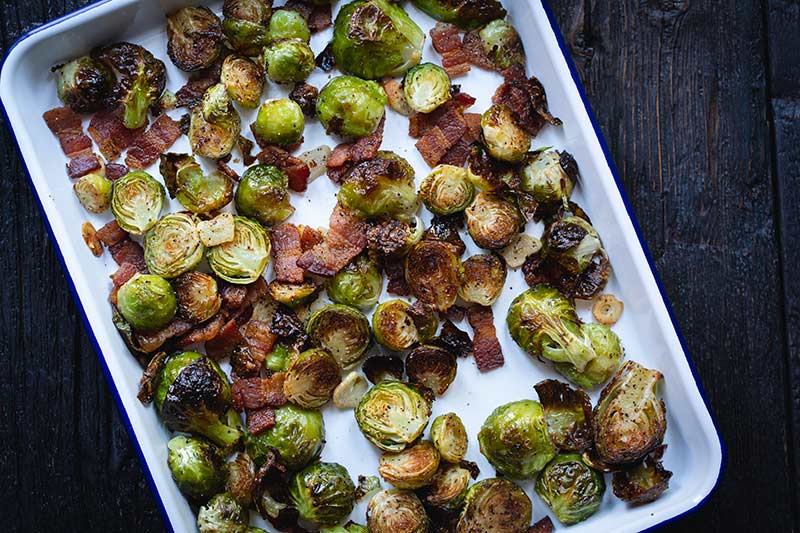 fully roasted brussels sprouts with bacon just out of the oven, still on the sheet pan.