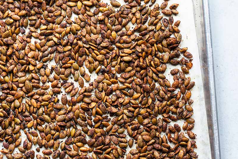 Roasted Pumpkin Seeds on a sheet pan lined with parchment