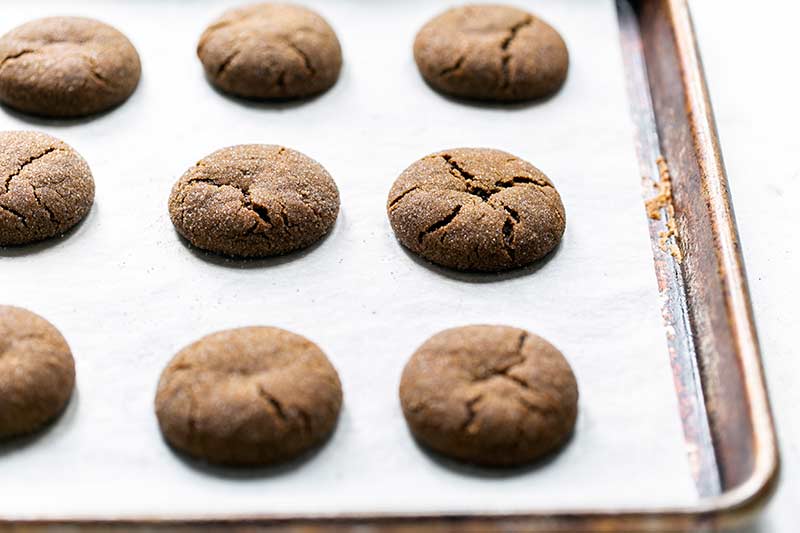 old fashioned molasses cookies on a sheet pan lined with parchment