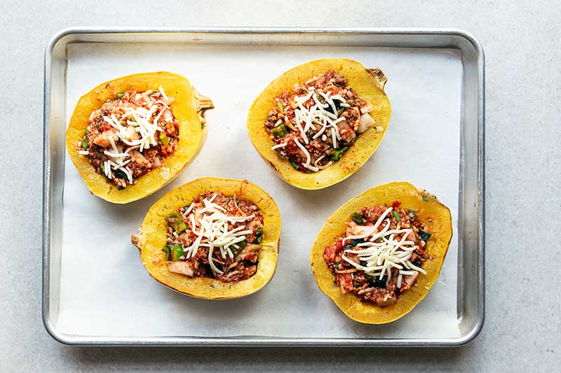 Filling stuffed into squash and topped with mozzarella cheese, prior to baking