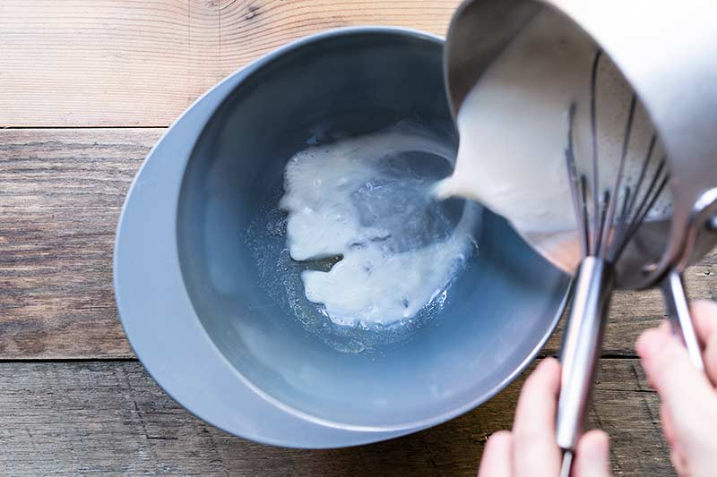 action shot of pouring hot cream mixture into gelatin