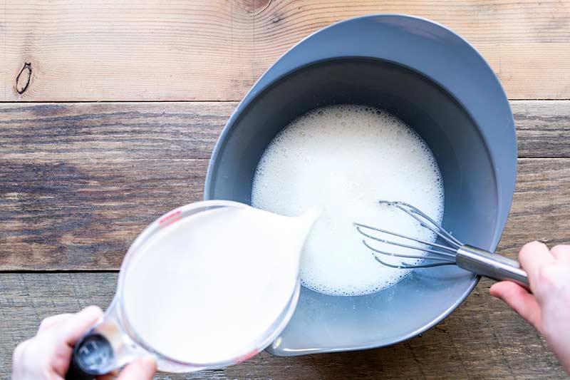 action shot of whisking buttermilk into cooled cream and gelatin mixture