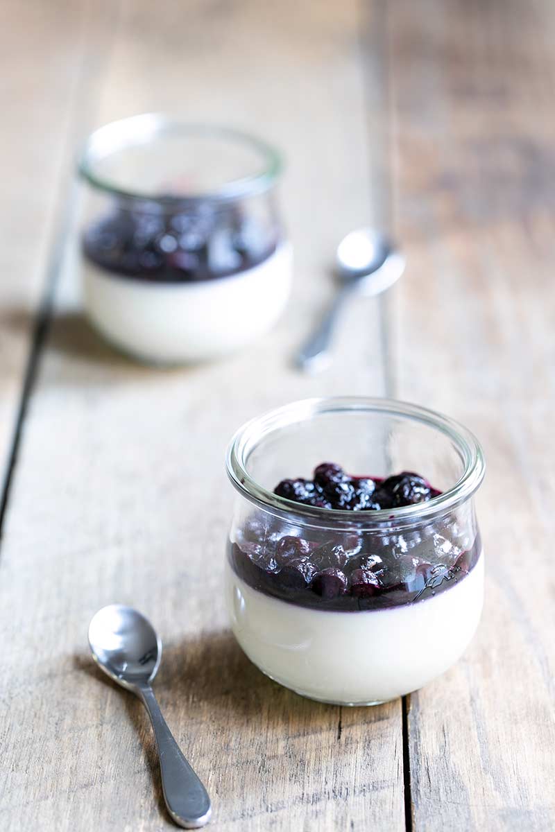 Buttermilk panna cotta recipe topped with blueberry compote, served in two mason jars