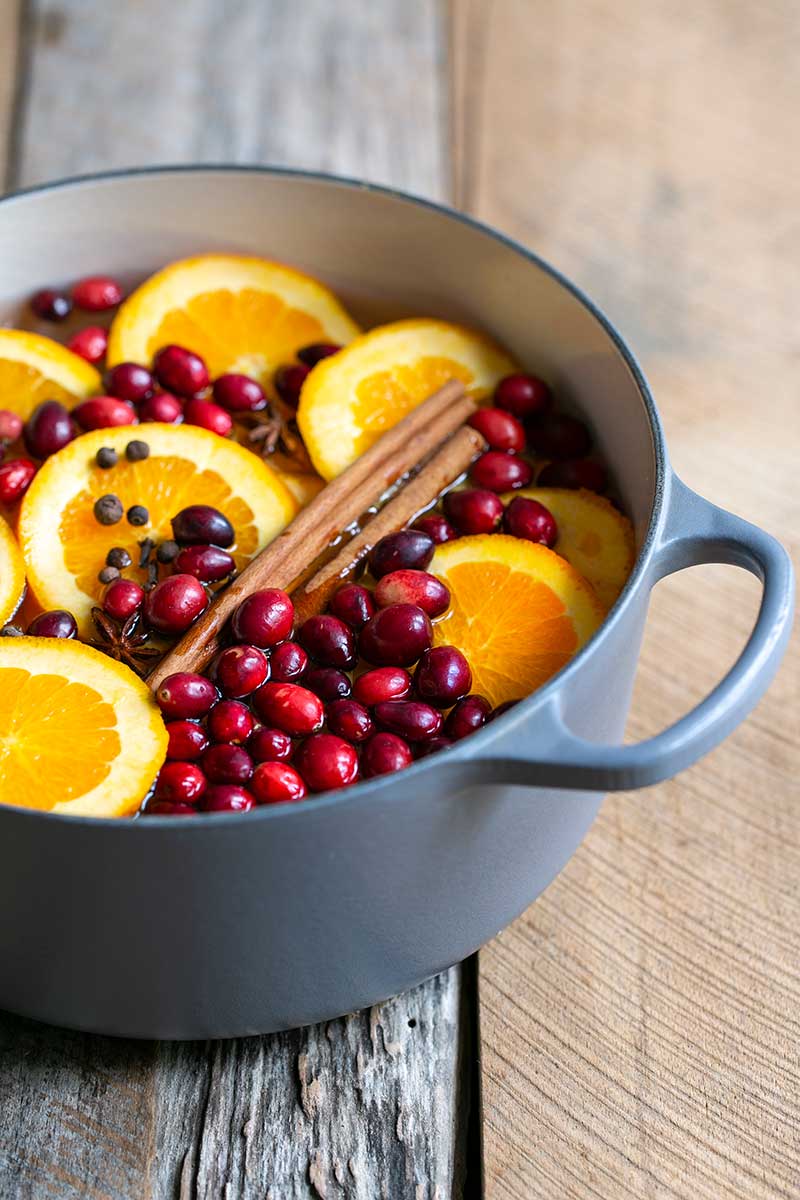 pot of orange slices, cinnamon and fresh cranberries, ready for simmering