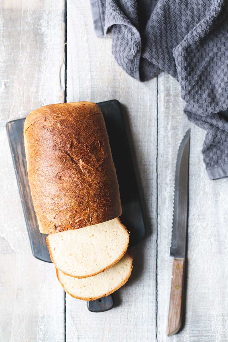 Sliced milk bread on a bread board.