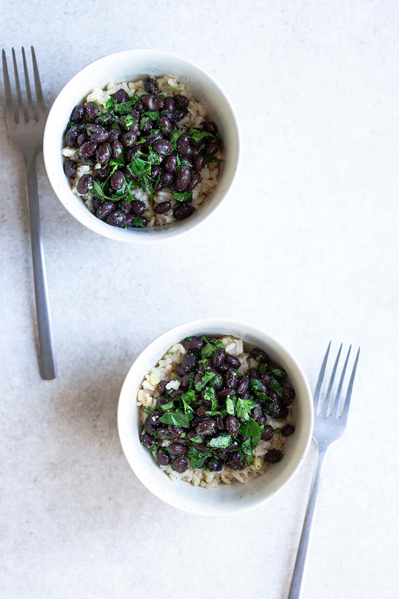 Black beans and rice recipe in a bowl next to a fork. 