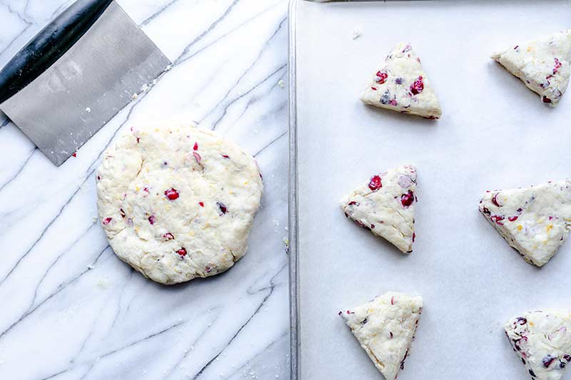 Shaping the dough into scones and placing on a parchment-lined sheet pan.
