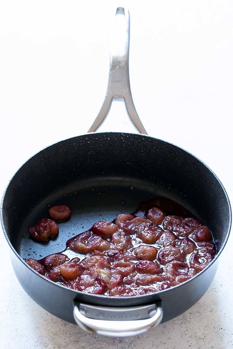 grapes cooked in a skillet until soft and juicy.