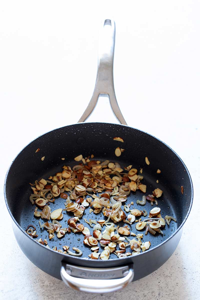 Almonds and shallots cooked in a skillet until the shallots are soft and the nuts are toasted.