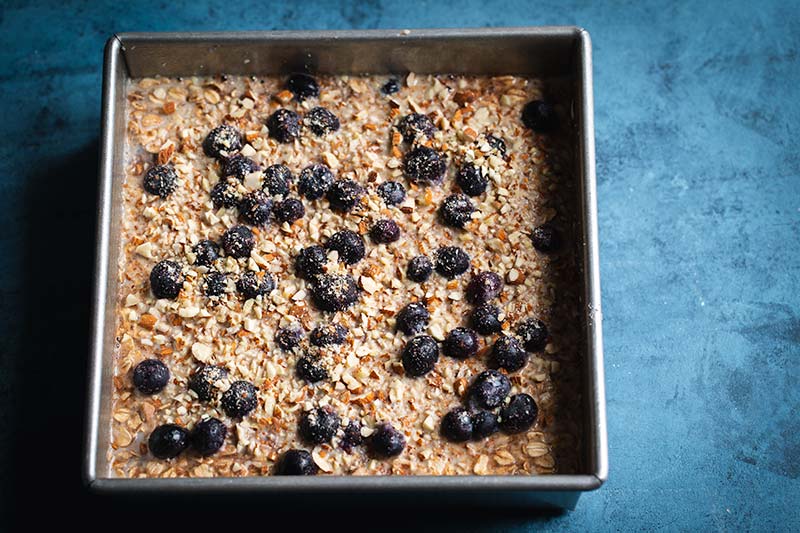 The wet ingredients, blueberries, and nuts added on top of the dry ingredients