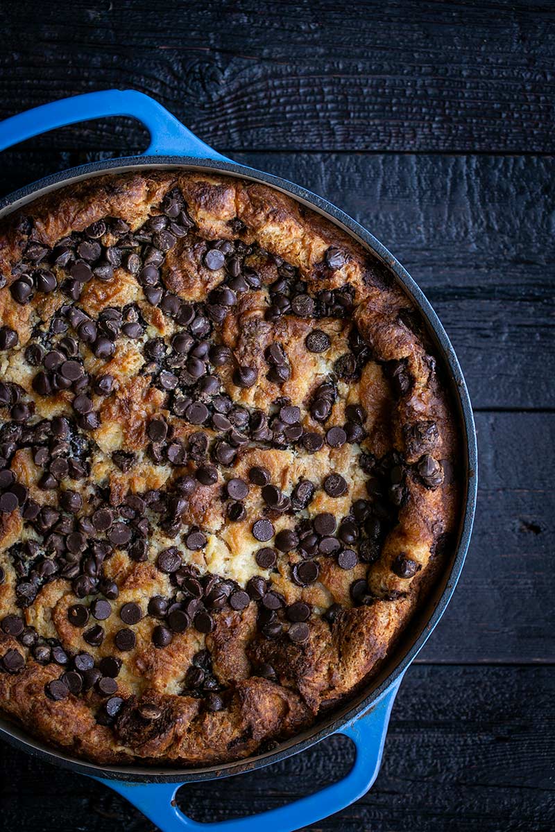 Chocolate bread pudding in a round blue baking dish.