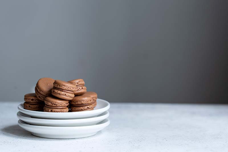 Chocolate macarons stacked up on a plate