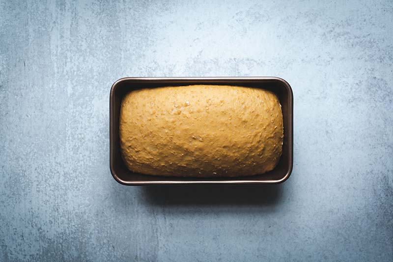 Bread dough in a loaf pan after it has doubled in size