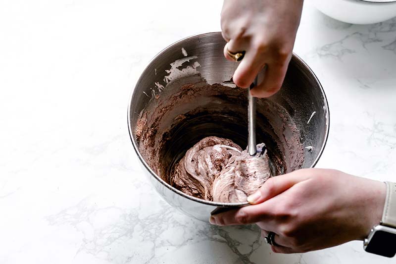 Stirring together dry ingredients with meringue in the stand mixer bowl