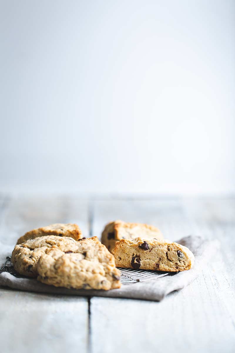 Chocolate chip scones on a round cooling rack and napkin