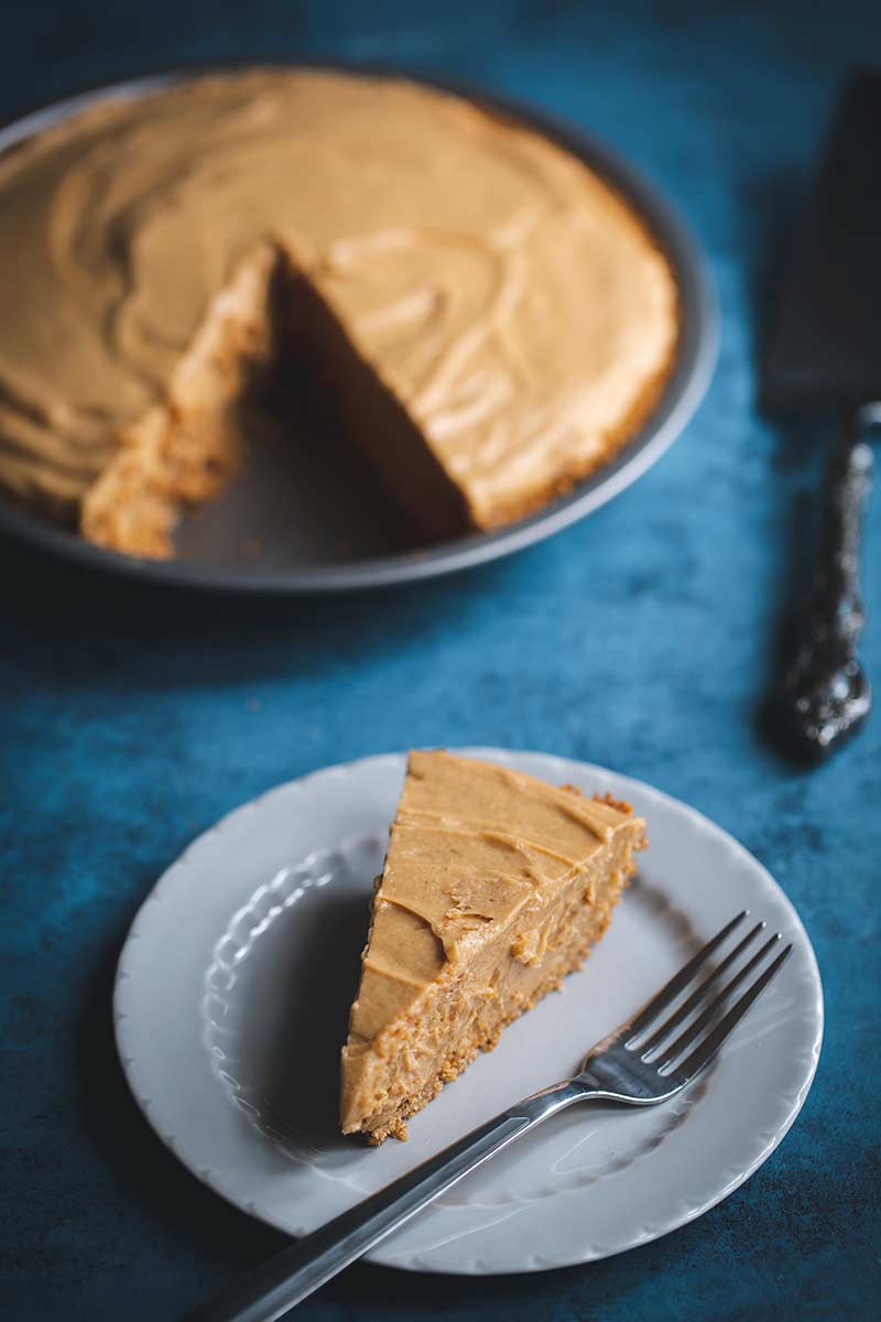 A slice of peanut butter pie in front of the remaining pie