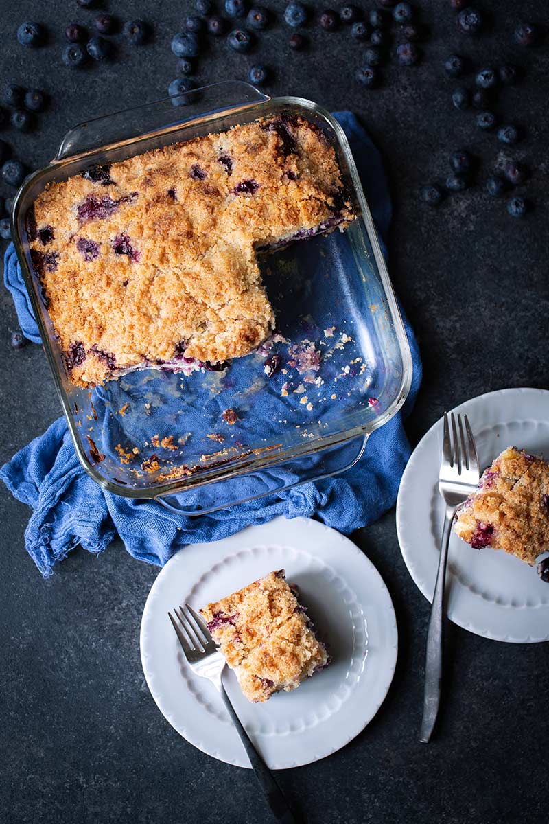 Two slices of cake next to blueberry buckle