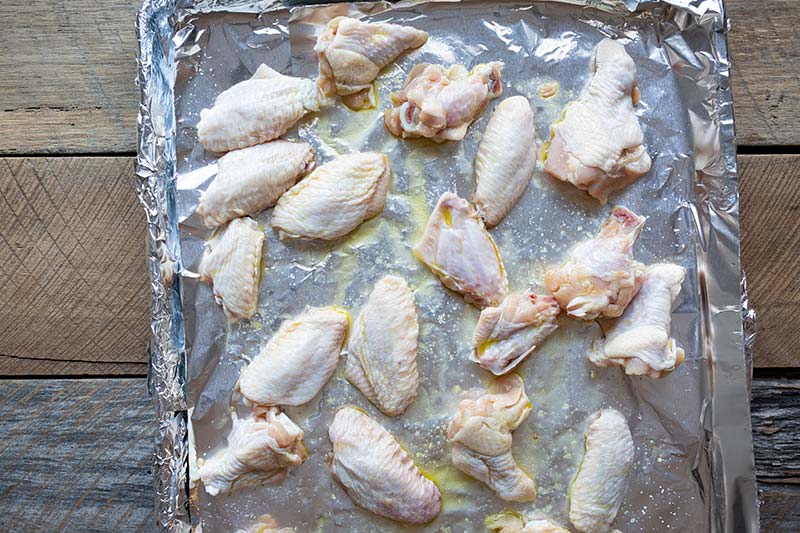 Chicken wings on a sheet pan lined with foil. 