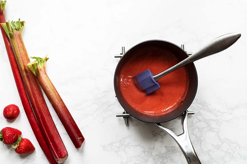 Cooked strawberries and rhubarb pureed in a saucepan