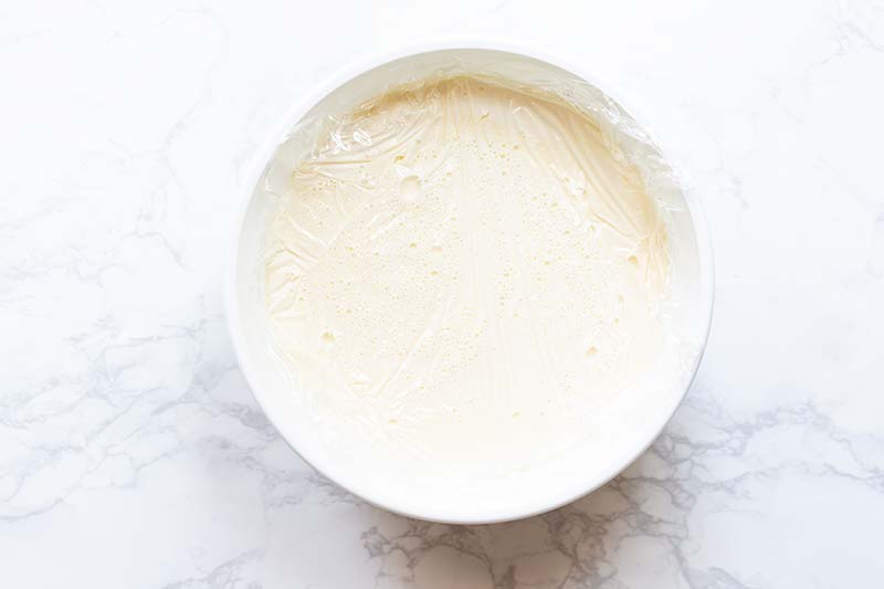 Plastic wrap pressed firmly against the gelato base